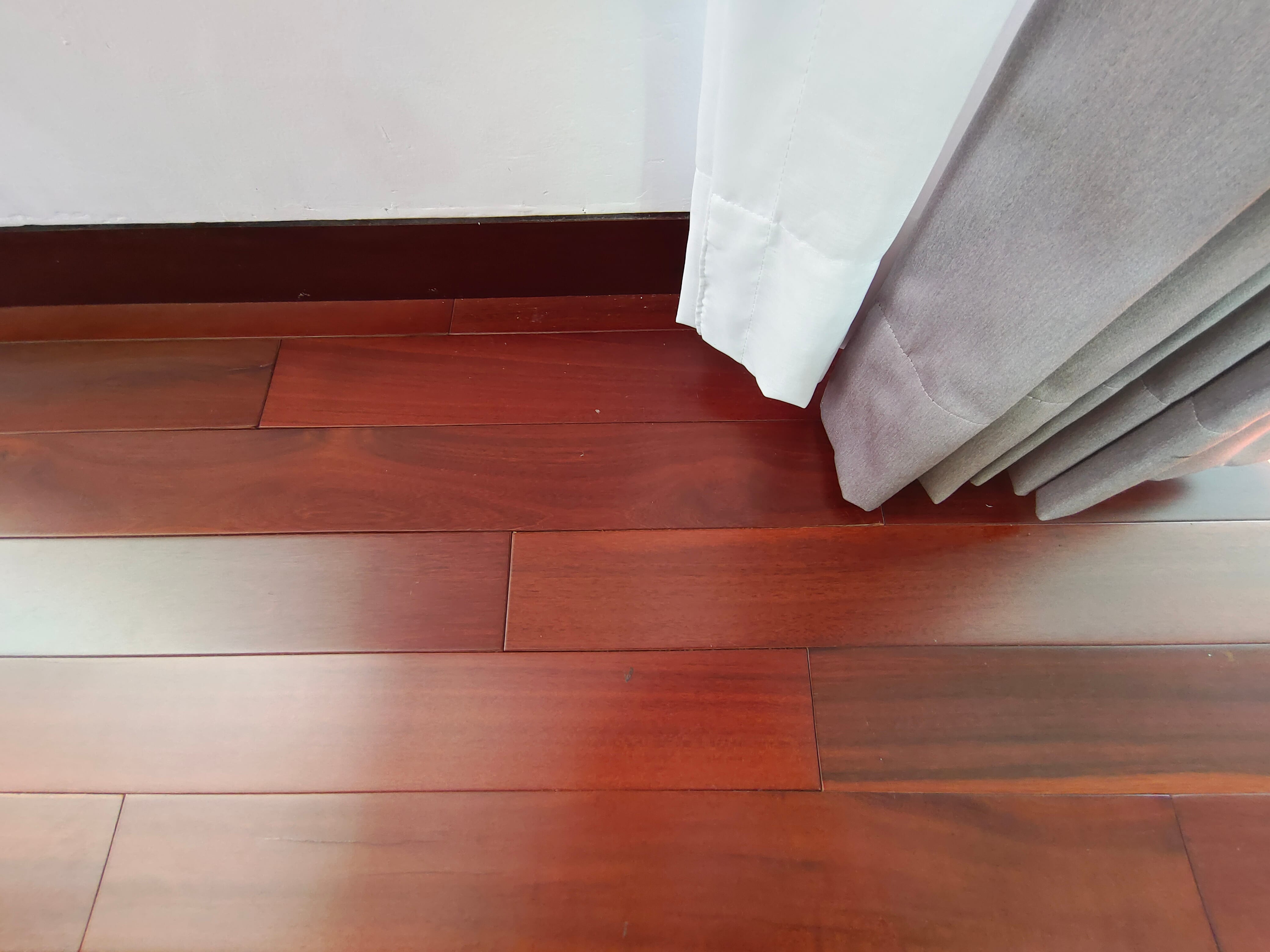 Close-up of dark solid wood strip flooring showing grain and surface finish at Kowi Bangka by Reywood